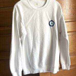 White sweatshirt with “evil eye symbol”.